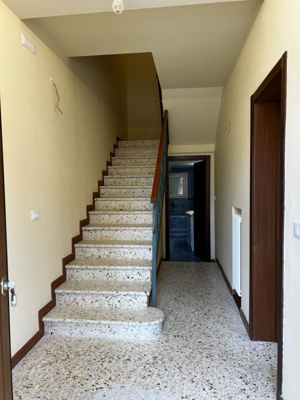 Entrando si trova di fronte l’accesso al bagno e la rampa di scale. Sulla destra si accede a 3 gr...