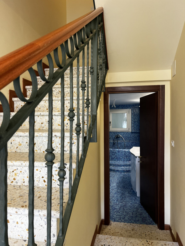 Entrando si trova di fronte l’accesso al bagno e la rampa di scale. Sulla destra si accede a 3 gr...