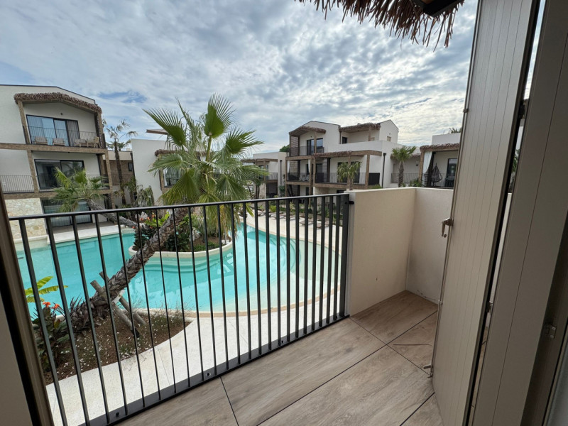 Immersi in un paesaggio caraibico tra sabbia bianca e palme verdi, in un residence dallo stile un...