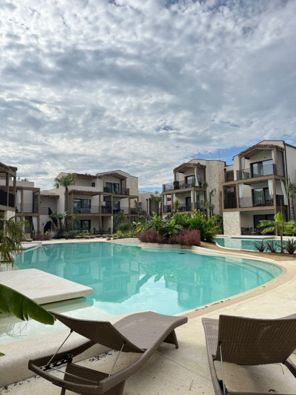 Immersi in un paesaggio caraibico tra sabbia bianca e palme verdi, in un residence dallo stile un...